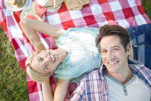 Happy couple lying together at the park