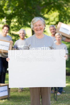 Happy volunteer grandmother holding blank