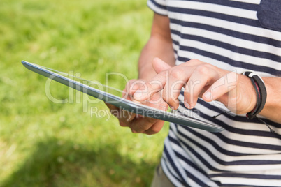 Man using a tablet in the park Man using a tablet in the park
