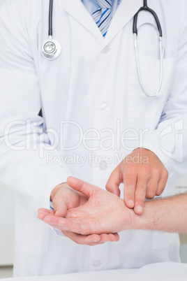 Doctor checking patients pulse rate