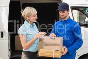 Delivery driver showing where to sign to customer