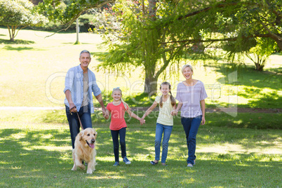 Happy family walking in the park with their dog