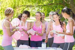 Smiling women organising event for breast cancer awareness