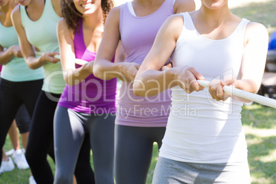 Fitness group playing tug of war