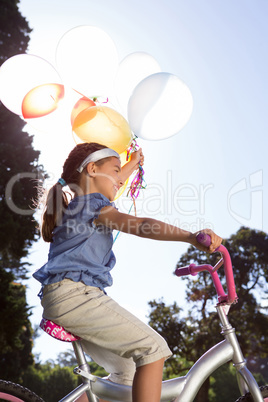 Happy little girl holding balloons