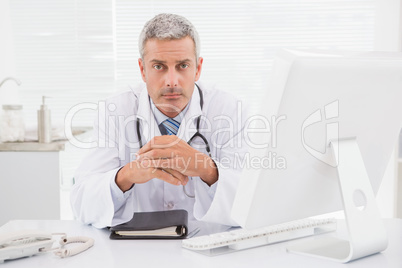 Unsmiling doctor looking at camera