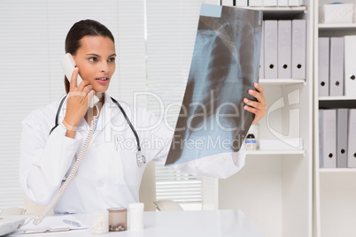Doctor on the phone analysing xray results