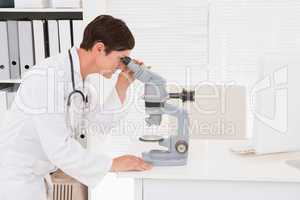 Veterinarian looking through microscope