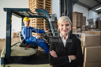 Smiling warehouse manager standing with arms crossed