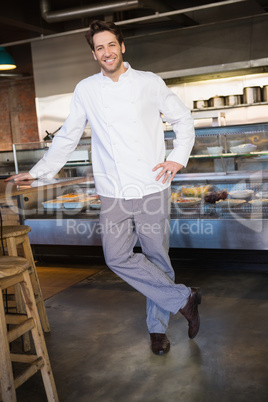 Portrait of happy baker leaning on counter