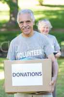 Happy volunteer senior holding donation box