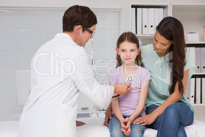 Doctor examining little girl with her mother