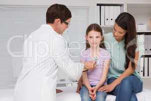 Doctor examining little girl with her mother