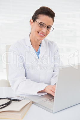 Happy doctor using laptop