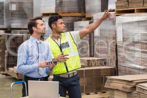 Warehouse worker showing something to his manager