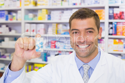 Handsome pharmacist showing medicine jar