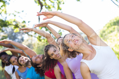 Fitness group doing yoga in park