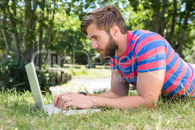 Hipster using laptop in the park