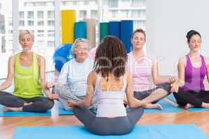 People practicing lotus position in yoga class