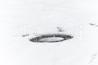 Kanaldeckel mit Schnee