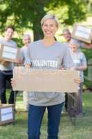 Happy volunteer blonde holding blank