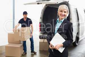 Delivery driver packing his van with manager smiling