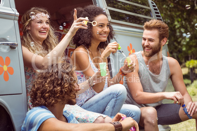 Hipsters blowing bubbles in camper van