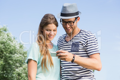 Cute couple in the park looking at selfie