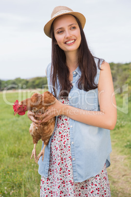 Happy brunette holding her chicken