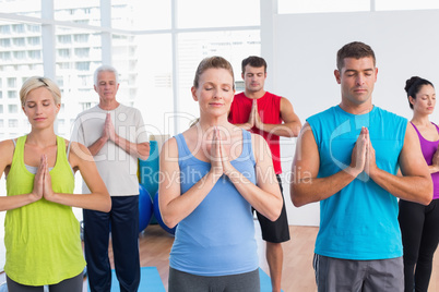 People meditating with hands joined in fitness club