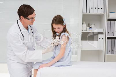 Doctor doing injection at a little girl