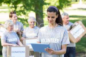 Smiling volunteer brunette using tablet pc