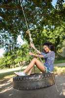 Pretty young woman in tire swing