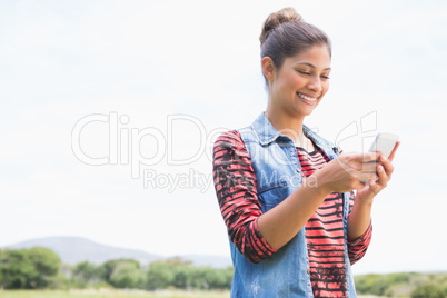 Pretty brunette texting in the park