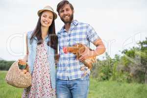 Happy farmers holding chicken and eggs