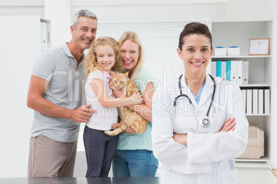 Veterinarian and cat owners smiling at camera