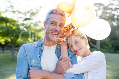 Happy couple holding balloons at the park