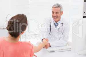 Happy doctor handshake at his patient