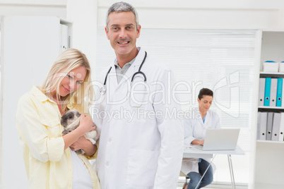 Veterinarian and cat owner smiling at camera