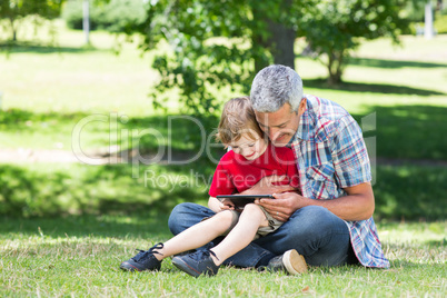 Happy father using tablet pc with his son