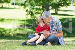 Happy father using tablet pc with his son