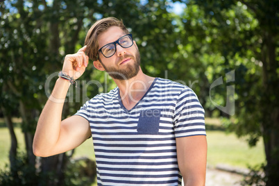 Handsome hipster thinking in the park