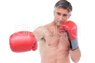 Fit man punching with boxing gloves