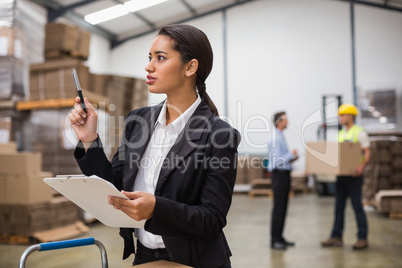 Pretty warehouse manager checking inventory