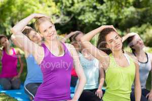 Fitness group doing yoga in park