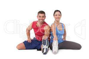 Fit man and woman stretching legs