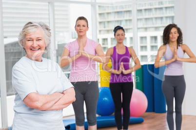 Senior woman with arms crossed standing in gym