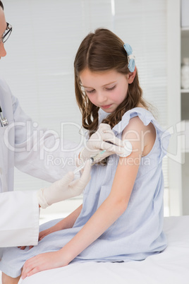 Doctor doing injection at a little girl