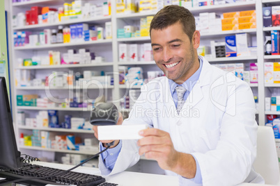 Handsome pharmacist scanning medicine box