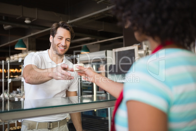 Waitress behind the counter giving cake to customer